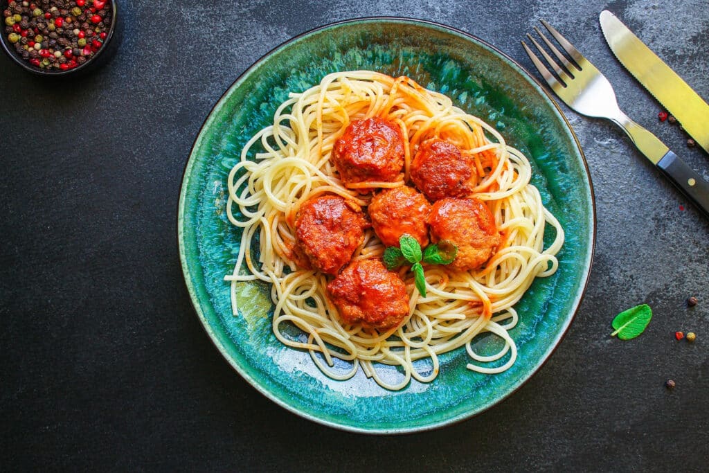 A plate of spaghetti topped with sauce and meatballs - A recipe of Topped with God's Grace