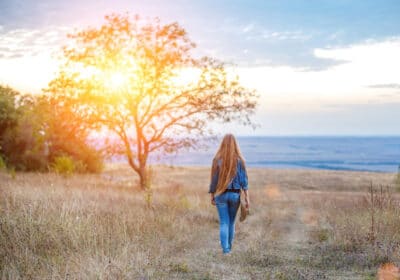 Woman walking in field turning pain into purpose