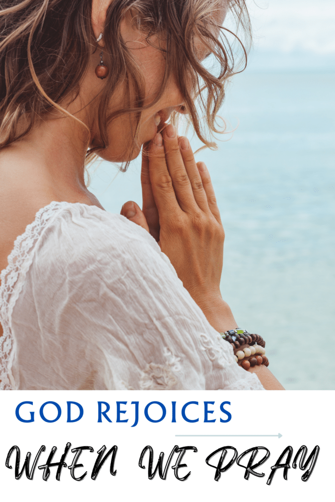 God rejoices when we pray - Pictured woman praying by ocean