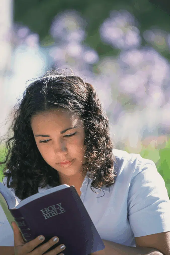 woman sitting outside reading bible